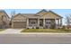Charming home with a stone facade, covered porch, and well-manicured lawn at 6302 E 135Th Ave, Thornton, CO 80602