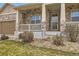 Inviting front porch with stone columns and a view of the well-maintained front yard at 6302 E 135Th Ave, Thornton, CO 80602