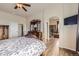 Bright main bedroom featuring a bed, ceiling fan, dresser and walk in bathroom at 6302 E 135Th Ave, Thornton, CO 80602