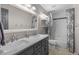 A well-lit bathroom with double sinks, marble countertop, and a bathtub with shower at 3656 E 134Th Dr, Thornton, CO 80241