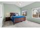 A spacious bedroom with light green walls, plush carpeting, and a comfortable queen-sized bed at 3656 E 134Th Dr, Thornton, CO 80241