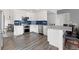 Bright kitchen with stainless steel appliances, white cabinetry, and a blue tiled backsplash at 3656 E 134Th Dr, Thornton, CO 80241