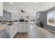 Open-concept space with an island kitchen flowing into a bright living room with a fireplace at 3656 E 134Th Dr, Thornton, CO 80241