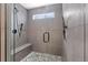 A modern tiled shower with gray stone floor, shower bench, and black shower hardware at 3656 E 134Th Dr, Thornton, CO 80241