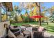 Inviting backyard patio with comfortable seating, a red umbrella, and a lush green lawn with mature trees at 3737 26Th St, Boulder, CO 80304