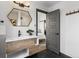 Stylish bathroom featuring a modern vanity, a hexagonal mirror, and a door leading to the bedroom at 8336 E 35Th Ave, Denver, CO 80238