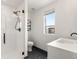 Bright bathroom with a glass-enclosed shower, a toilet, and a white vanity with black hardware at 8336 E 35Th Ave, Denver, CO 80238