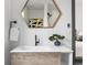 Close-up of bathroom vanity with hexagon mirror and a small decorative bonsai tree at 8336 E 35Th Ave, Denver, CO 80238