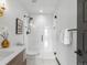 Modern bathroom with a glass shower, white tiles, and a vanity with a gold accent at 8336 E 35Th Ave, Denver, CO 80238