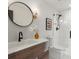 Elegant bathroom featuring a modern vanity, round mirror and a glass enclosed shower at 8336 E 35Th Ave, Denver, CO 80238
