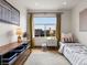 Well-lit bedroom featuring a single bed, storage shelves, and a large window offering neighborhood views at 8336 E 35Th Ave, Denver, CO 80238