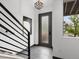 Modern entryway with sleek staircase, frosted glass door and contemporary artwork at 8336 E 35Th Ave, Denver, CO 80238