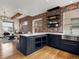 Modern kitchen boasts a stainless steel sink, open shelving, white countertops, and sleek navy blue cabinetry at 8336 E 35Th Ave, Denver, CO 80238