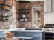 Modern kitchen featuring brick accents, quartz countertops, stainless steel appliances, and floating shelves at 8336 E 35Th Ave, Denver, CO 80238