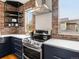 The kitchen features a stainless steel range, brick walls, undermount sink, and white countertops at 8336 E 35Th Ave, Denver, CO 80238