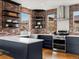 Bright kitchen boasts stainless steel appliances, floating shelves, brick accents, and hardwood flooring at 8336 E 35Th Ave, Denver, CO 80238