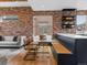 Open-concept space with brick walls, hardwood floors, a glass dining table, and comfortable seating area at 8336 E 35Th Ave, Denver, CO 80238
