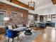 Modern living room with exposed brick wall, wood beam and contemporary furnishings at 8336 E 35Th Ave, Denver, CO 80238