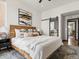 Bedroom features modern decor, large windows, stylish furniture, and a sliding mirror door at 8336 E 35Th Ave, Denver, CO 80238