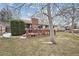 View of the backyard with a wooden fence, deck and mature trees at 8205 Dudley Way, Arvada, CO 80005
