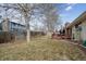 Large backyard with mature trees, wooden fence, and back deck visible at 8205 Dudley Way, Arvada, CO 80005