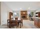 Open floor plan with dining table and brick fireplace, with view into the kitchen at 8205 Dudley Way, Arvada, CO 80005