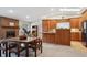 Open floor plan kitchen area featuring wood cabinets, brick fireplace, and dining table at 8205 Dudley Way, Arvada, CO 80005