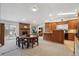 Open-concept kitchen area with brick fireplace, wood cabinetry, and adjacent dining space at 8205 Dudley Way, Arvada, CO 80005