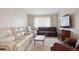 Cozy living room featuring plush seating, carpet flooring and natural light from the large windows at 8205 Dudley Way, Arvada, CO 80005