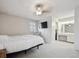 Spacious main bedroom with a ceiling fan, ensuite vanity, TV, and neutral carpeting at 8205 Dudley Way, Arvada, CO 80005