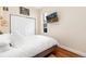 Cozy bedroom with hardwood floors, a large closet, a view through the window, and a wall-mounted TV at 3220 W 24Th Ave, Denver, CO 80211