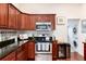 Renovated kitchen featuring cherry cabinets, stainless steel appliances, modern countertops, and an adjacent laundry area at 3220 W 24Th Ave, Denver, CO 80211