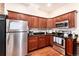 Bright kitchen featuring stainless steel appliances, rich wood cabinets, granite countertops, and hardwood floors at 3220 W 24Th Ave, Denver, CO 80211