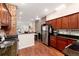 Inviting kitchen featuring stainless steel appliances, cherry cabinets, breakfast bar, and an exposed brick accent wall at 3220 W 24Th Ave, Denver, CO 80211