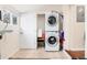Efficient laundry room with stacked washer and dryer, white door and storage at 3220 W 24Th Ave, Denver, CO 80211