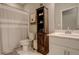 Bright bathroom featuring a toilet, shower with curtain, decorative cabinet, and modern sink at 9279 Merino Ct # D, Littleton, CO 80125