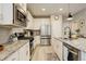 Bright kitchen features stainless steel appliances, granite counters, and wood flooring at 9279 Merino Ct # D, Littleton, CO 80125
