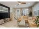 Comfortable living room featuring a stylish sectional sofa, modern entertainment center, and large windows at 9279 Merino Ct # D, Littleton, CO 80125