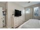 Main bedroom with a large dresser, ensuite door, and a window view at 9279 Merino Ct # D, Littleton, CO 80125