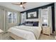 Stylish main bedroom features a king bed, statement wall, and bright windows at 9279 Merino Ct # D, Littleton, CO 80125