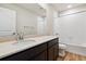 Bright bathroom featuring a granite countertop, dark wood cabinets, and a shower-over-tub setup at 42754 Calusa Pines Rd, Elizabeth, CO 80107