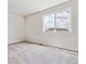Well-lit bedroom showcasing plush carpeting and a large window offering neighborhood views at 42754 Calusa Pines Rd, Elizabeth, CO 80107