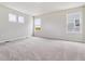 Spacious bedroom with three windows, carpeted floor, and neutral color scheme at 42754 Calusa Pines Rd, Elizabeth, CO 80107