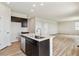 Kitchen with island sink, stainless steel dishwasher, dark cabinets, and open floor plan at 42754 Calusa Pines Rd, Elizabeth, CO 80107