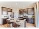 Modern kitchen with stainless steel appliances, dark cabinets, and a large island with seating at 42754 Calusa Pines Rd, Elizabeth, CO 80107