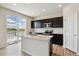 Modern kitchen with stainless steel appliances, dark cabinetry, island sink, and a sliding glass door to a deck at 42754 Calusa Pines Rd, Elizabeth, CO 80107