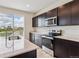 Modern kitchen featuring stainless steel appliances, an island sink, and dark wood cabinetry at 42754 Calusa Pines Rd, Elizabeth, CO 80107