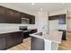 Kitchen with stainless steel appliances, dark wood cabinets, white countertops, and island with sink at 42754 Calusa Pines Rd, Elizabeth, CO 80107