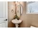 Stylish powder room features a pedestal sink, oval mirror, neutral walls and a window with blinds at 42754 Calusa Pines Rd, Elizabeth, CO 80107
