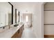 Bright bathroom featuring dual sinks, a modern soaking tub, and walk-in closet at 16133 W 14Th Ave, Golden, CO 80401